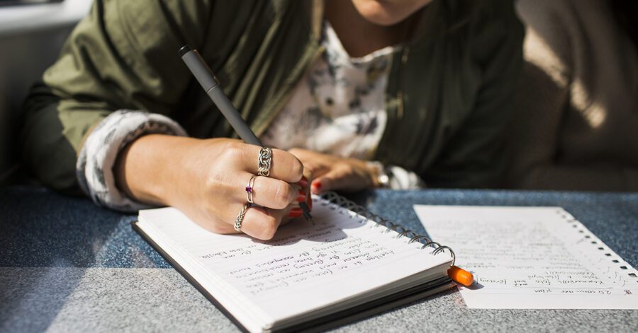 Homeschool student writing in a notebook to avoid plagiarism.