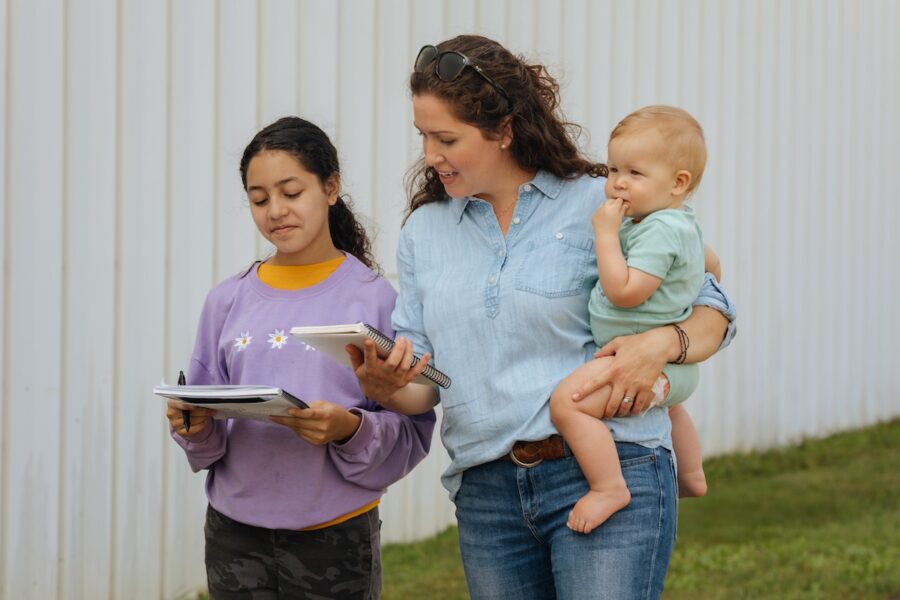 A homeschool family holding books outside