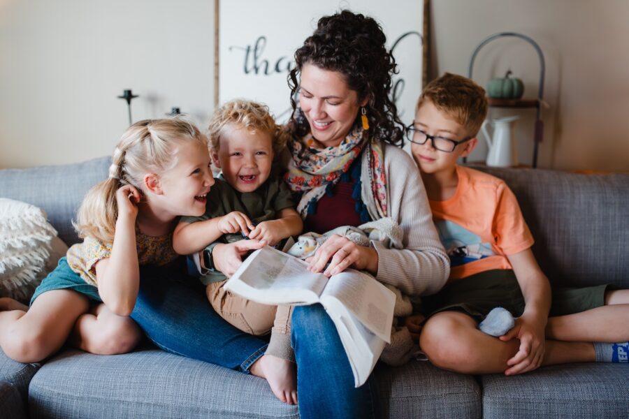 A homeschool mom reading to her kids on a couch