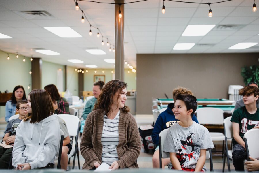 A homeschool mom and son smiling at each other at a community