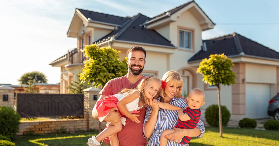 Parents and children having fun standing in front of their new house with a solid foundation