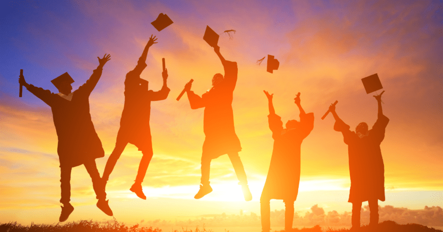 Graduates silhouetted by the sunset.