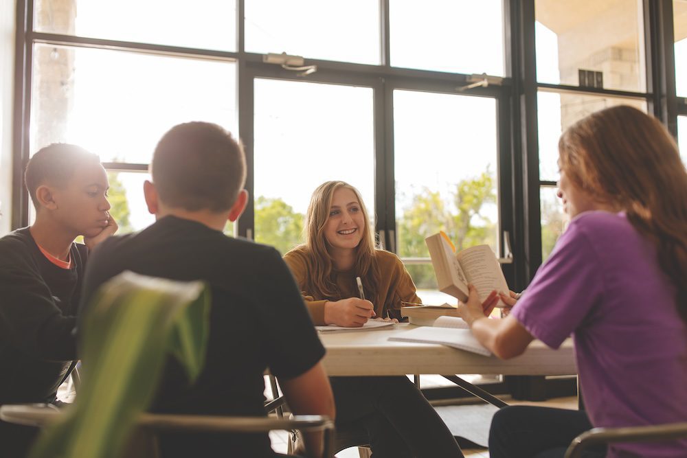 students reading and discussing around a table
