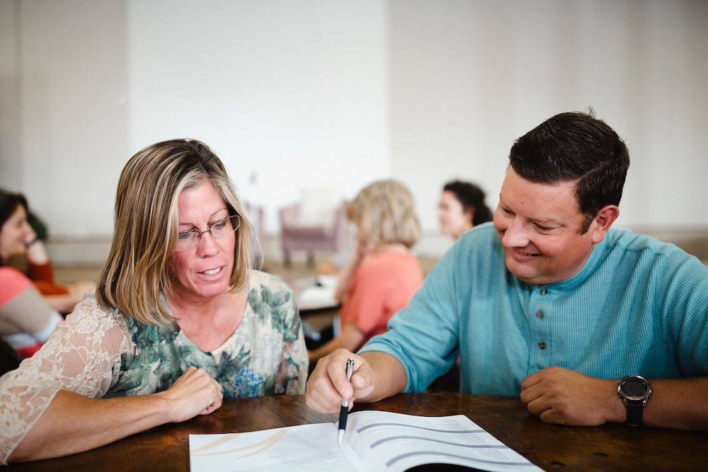 two parents working through a Practicum notebook