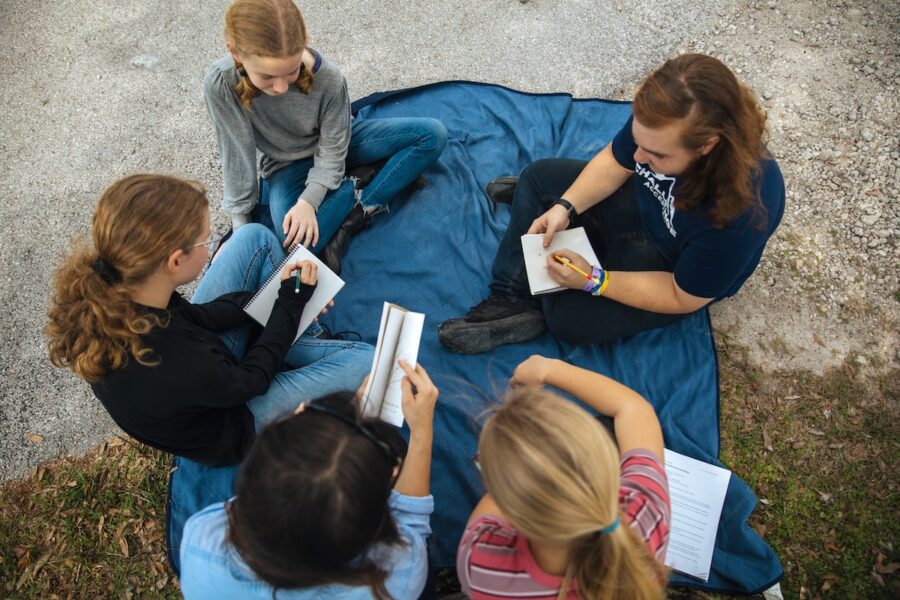 An overhead shot of students reading books in a circle